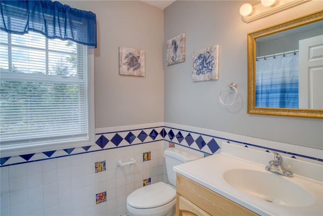 Bathroom featuring vanity, tile walls, and toilet | Image 24