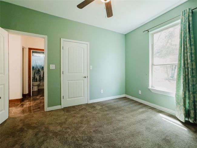 Unfurnished bedroom with multiple windows, carpet flooring, and ceiling fan | Image 29