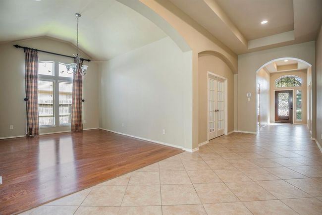 Just off the entry, the formal dining room is filled with natural light from the tall front windows—perfect for hosting holiday dinners or intimate gatherings. Across the way, double French doors open to a private home office, ideal for working remotely or creating a quiet retreat. | Image 5
