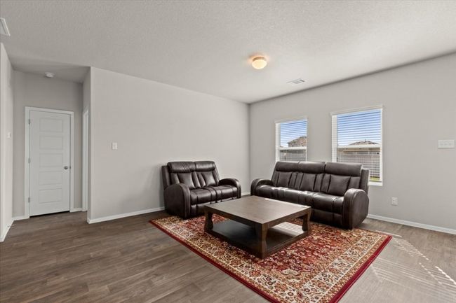 Living area featuring wood finished floors, baseboards, and a textured ceiling | Image 9