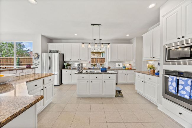 Stainless steel appliances and white cabinets creates open and crisp kitchen experience. | Image 15