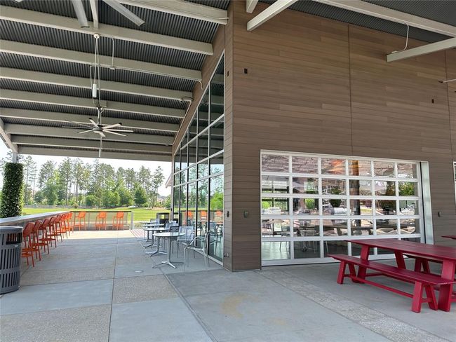 Enjoy a relaxing atmosphere at this modern café, featuring ample outdoor seating and scenic views, perfect for unwinding or socializing. | Image 49