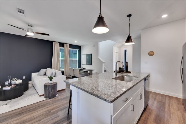 Kitchen with visible vents, open floor plan, a sink, and wood finished floors | Image 9