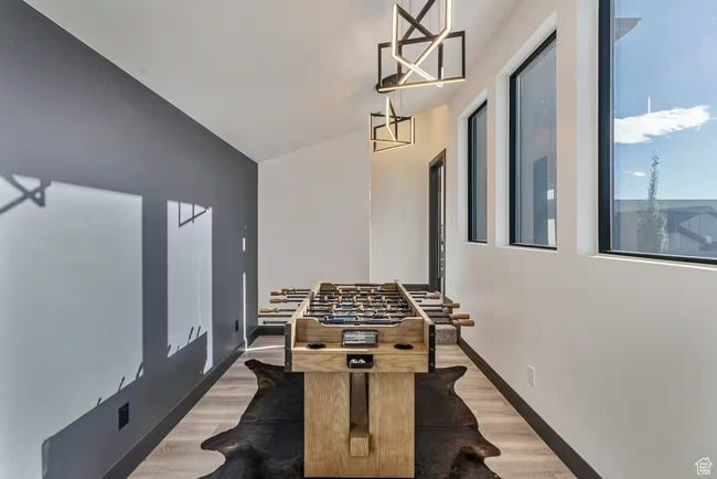 Playroom featuring vaulted ceiling, wood finished floors, and baseboards | Image 36