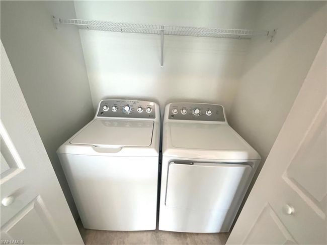 Laundry area with washer and dryer and wood finished floors | Image 24