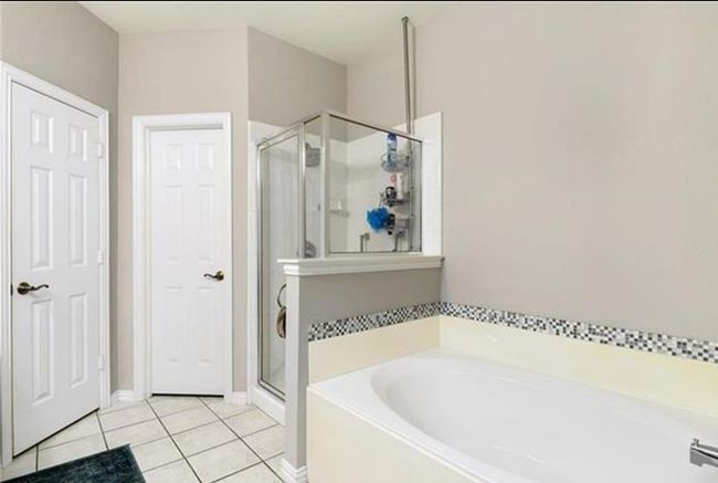 Bathroom featuring shower with separate bathtub and tile floors | Image 18