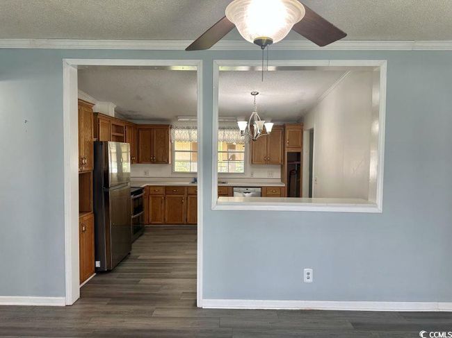 Kitchen with appliances with stainless steel finishes, a chandelier, a textured ceiling, crown molding. | Image 15