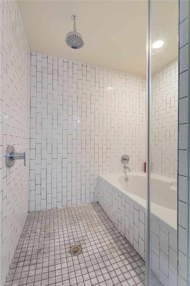 Bathroom with tiled shower, tile patterned flooring, and tile walls | Image 19
