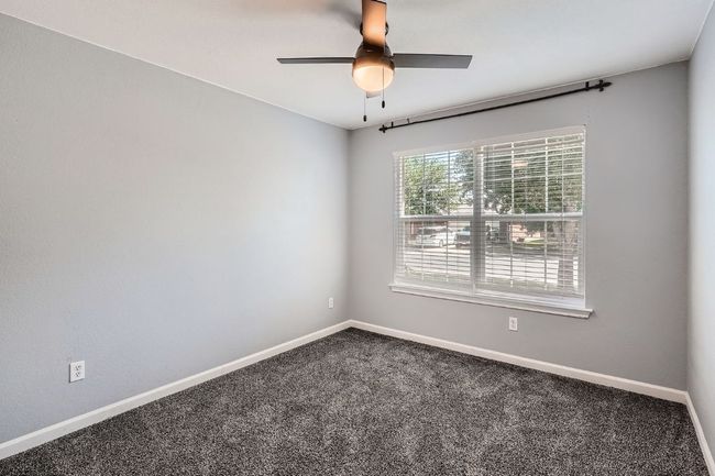 Carpeted empty room with ceiling fan and baseboards | Image 18