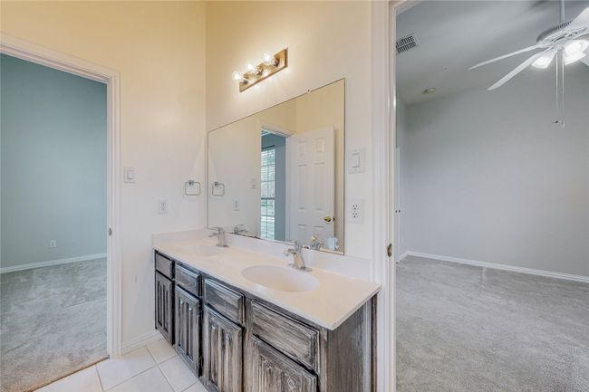 Bathroom with a ceiling fan, double vanity, a towering ceiling, and baseboards | Image 34