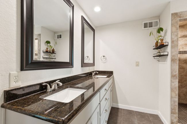 Ensuite bathroom with double vanity, a tile shower, and an oversized walk in closet. | Image 18