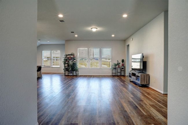 Living area with dark wood finished floors, baseboards, visible vents, and recessed lighting | Image 7