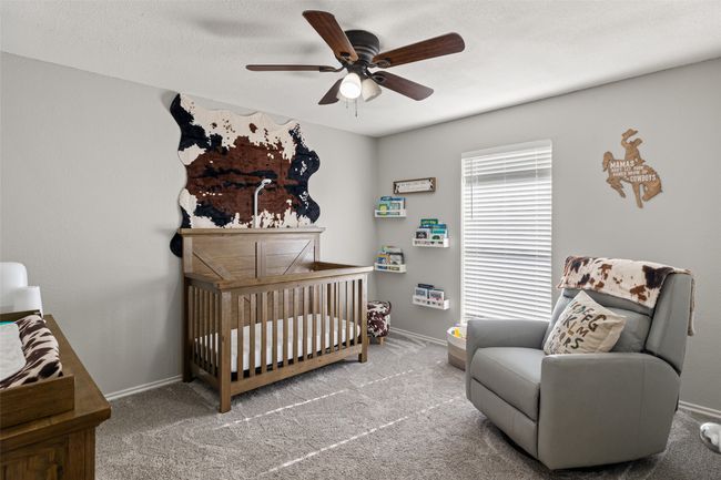 Bedroom featuring a ceiling fan, baseboards, carpet floors, and a nursery area | Image 18