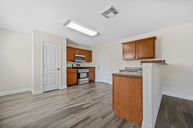 View into kitchen with breakfast bar and 2-car garage access. | Image 11