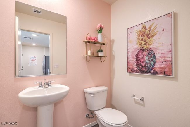 Half bathroom with baseboards, visible vents, toilet, and a sink | Image 18