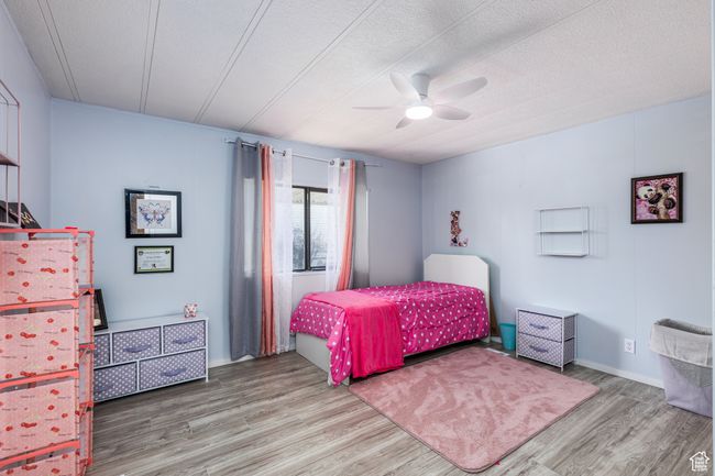 Bedroom featuring a textured ceiling, wood finished floors, and ceiling fan | Image 13