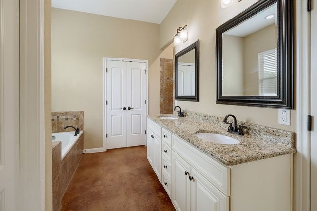 Bathroom featuring double vanity, a garden tub, baseboards, and a sink | Image 10