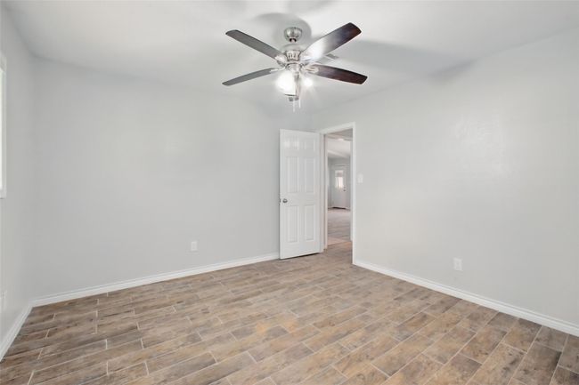 An alternate view of this secondary bedroom reveals its ideal location near the home's main areas, perfect for family, guests, or a home office. | Image 26