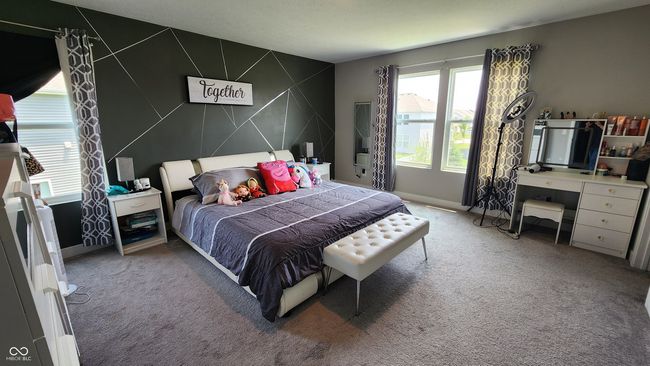 carpeted bedroom featuring an accent wall and a desk | Image 14