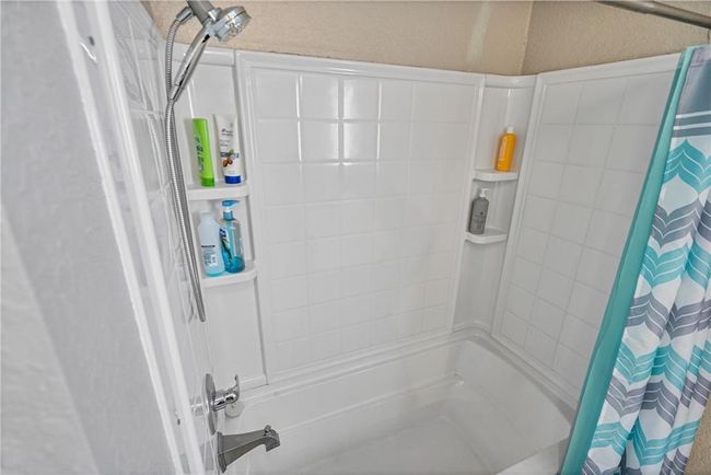 Bathroom featuring shower / bathtub combination with curtain | Image 35