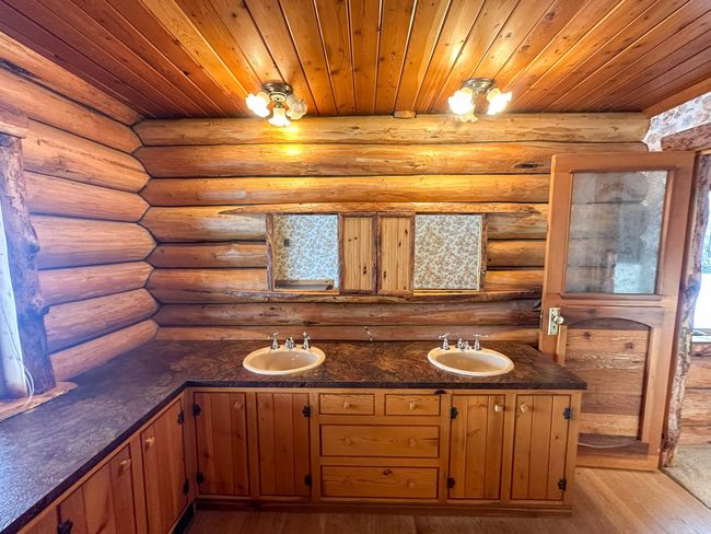 Bathroom with vanity, hardwood / wood-style flooring, wooden ceiling, and log walls | Image 42