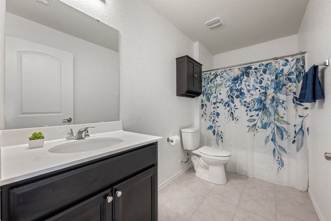 Bathroom with toilet, vanity, baseboards, tile patterned flooring, and visible vents | Image 29