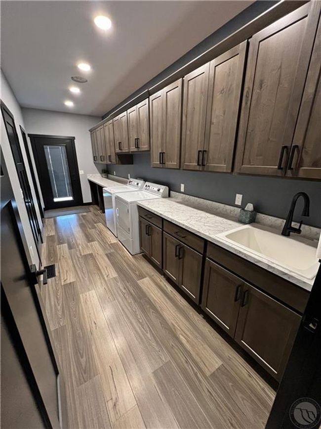 Spacious laundry room with half bath and tons of storage. The two lower cubbies at the end fit large dog beds perfectly ;) | Image 21