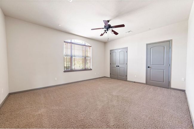 Unfurnished bedroom featuring carpet flooring, a ceiling fan, and a closet | Image 35