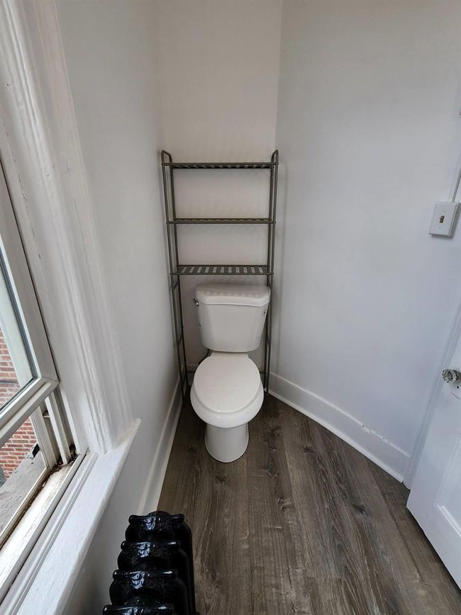 Bathroom featuring baseboards, wood finished floors, and toilet | Image 12