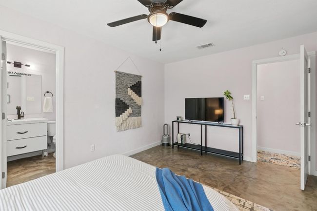 Bedroom with a sink, baseboards, a ceiling fan, connected bathroom, and concrete flooring | Image 14