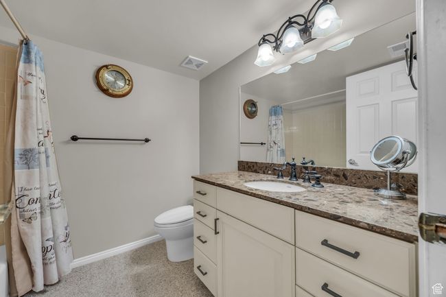Full bathroom featuring toilet, visible vents, baseboards, and speckled floor | Image 25