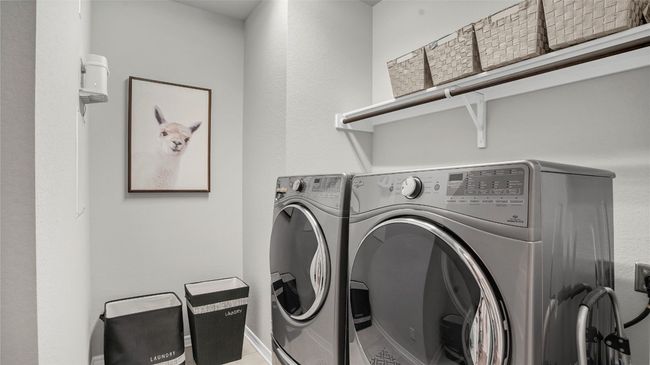 Washroom featuring washing machine and clothes dryer and laundry area | Image 25