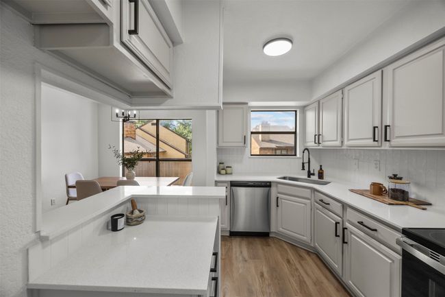 Kitchen featuring stainless steel appliances, light countertops, and decorative backsplash | Image 15