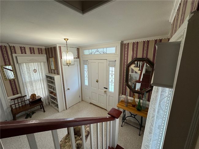 Entryway with wallpapered walls, a chandelier, and plenty of natural light | Image 24