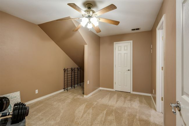 Additional living space with ceiling fan, visible vents, baseboards, and light carpet | Image 20
