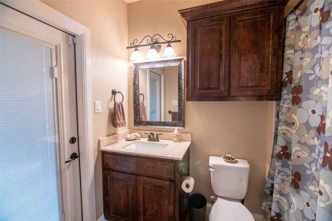 Bathroom with toilet, vanity, and a textured wall | Image 25