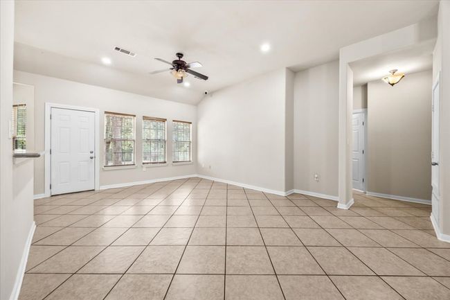Unfurnished living room featuring visible vents, ceiling fan, light tile patterned floors, and baseboards | Image 7