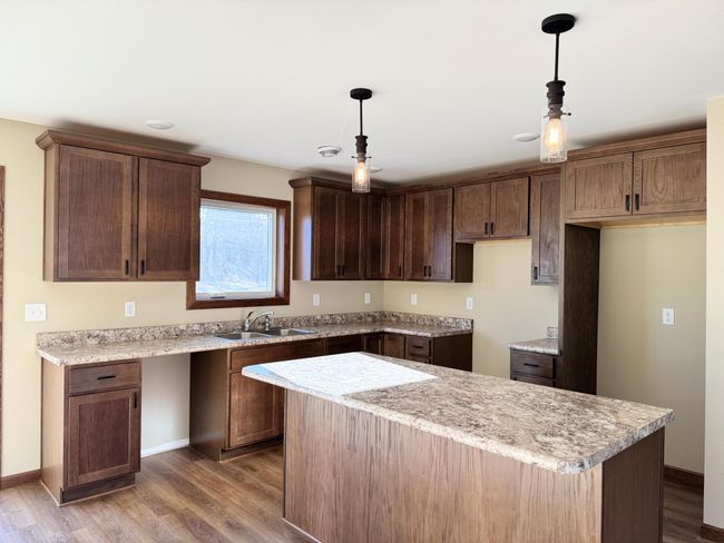 Beautiful walnut-toned cabinetry and a center island highlight this kitchen. | Image 4