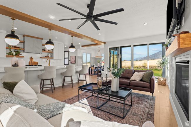 Living area with a mountain view, recessed lighting, light wood-style floors, beam ceiling, and a glass covered fireplace | Image 13