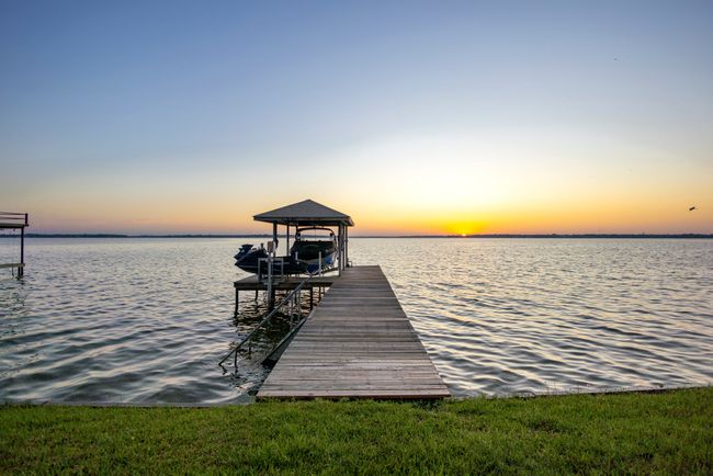 View of dock which features a boat lift and two jet ski lifts and convenient stair entry to the lake. | Image 23