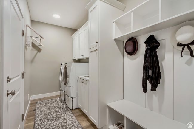 Laundry room featuring recessed lighting, independent washer and dryer, baseboards, cabinet space, and light wood-style flooring | Image 27
