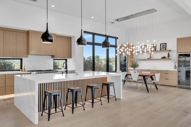 Kitchen featuring top of the line stainless steel appliances, custom modern cabinets, and light countertops | Image 10