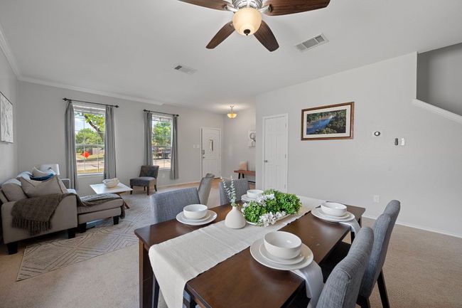 Dining space featuring light colored carpet, a ceiling fan, and baseboards | Image 7