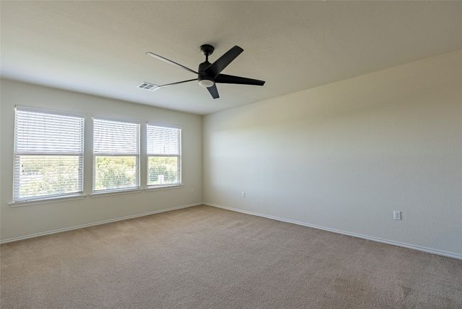 Carpeted empty room with a ceiling fan and baseboards | Image 10