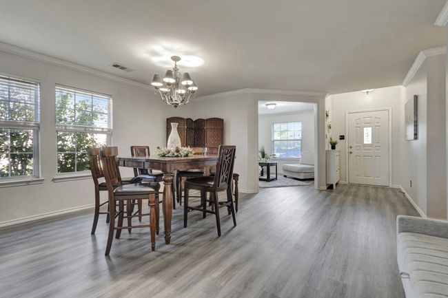 Dining space featuring hardwood / wood-style flooring, a notable chandelier, and ornamental molding | Image 6