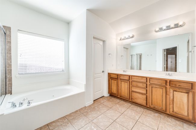Full bathroom with double vanity, a garden tub, tile patterned flooring, and a shower with door | Image 19