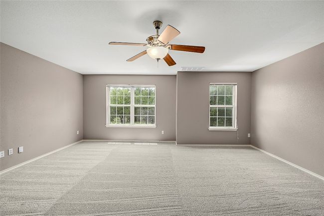 Empty room with a ceiling fan and light colored carpet | Image 18