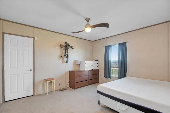 Bedroom with light carpet, crown molding, and a ceiling fan | Image 31