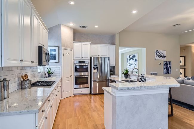 Thermador 5 burner gas cooktop, GE double ovens, microwave and KitchenAid dishwasher. Light refinished engineered hardwood floors | Image 12