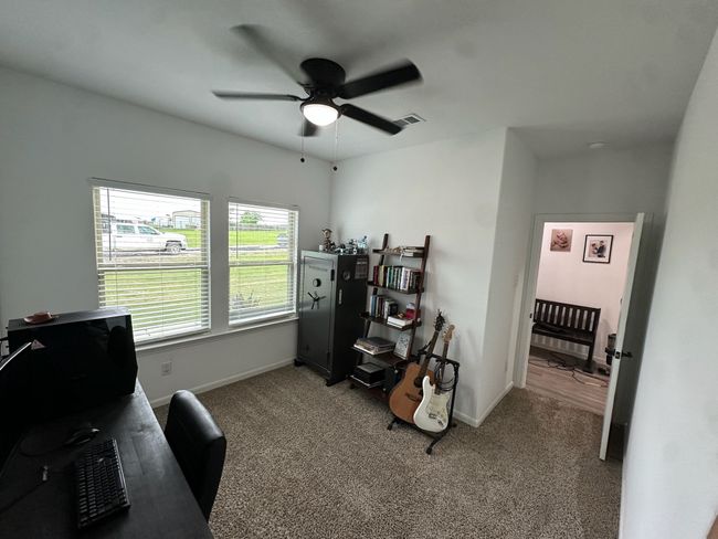 Living room with a raised ceiling, ceiling fan, recessed lighting, a fireplace, and light wood finished floors | Image 9